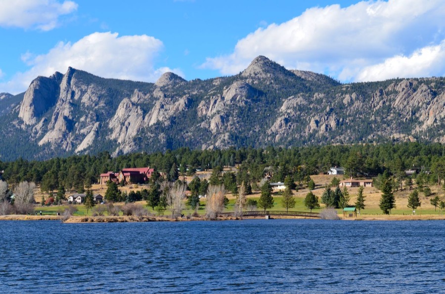 A Northern Colorado Front Range lake and foothills with homes at the base of the mountains.